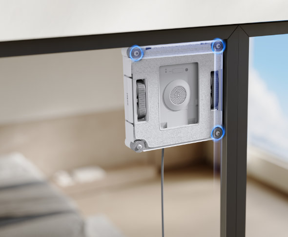 Robot Winbot myje narożnik okna w sypialni, na drugim planie widoczne łóżko